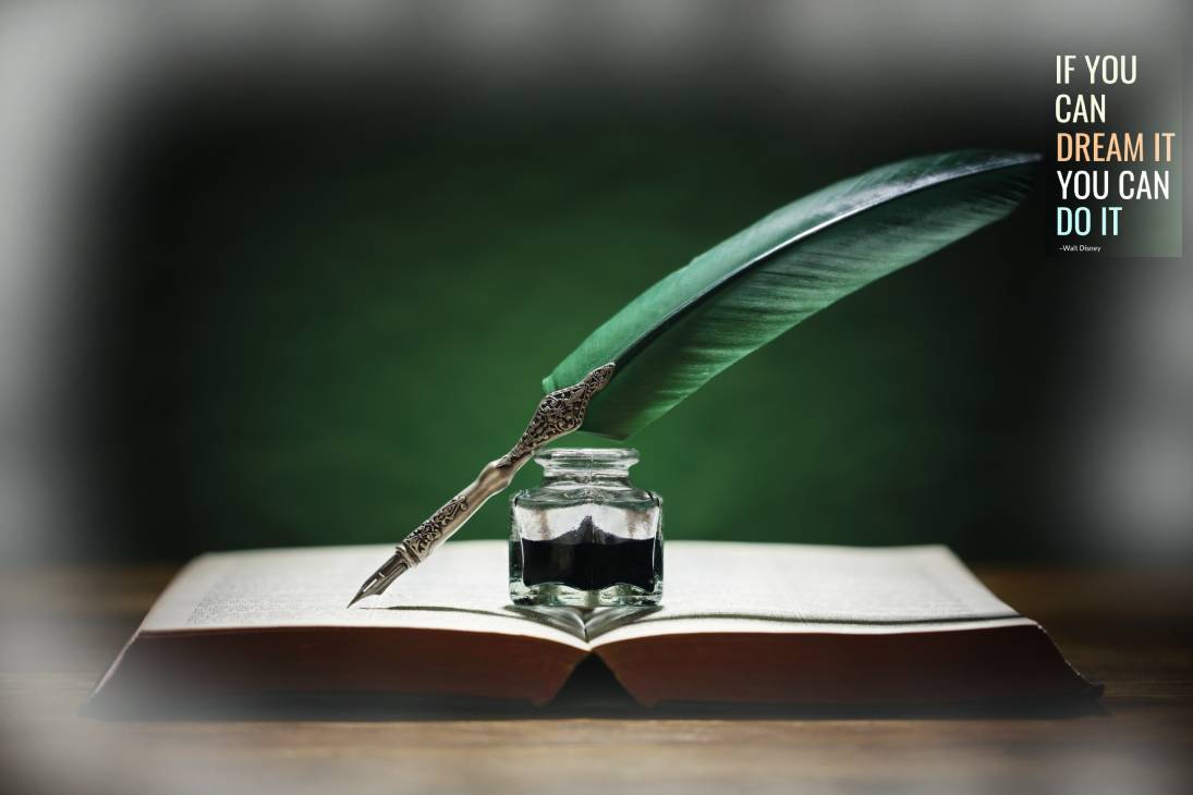 a feather and ink bottle on a book